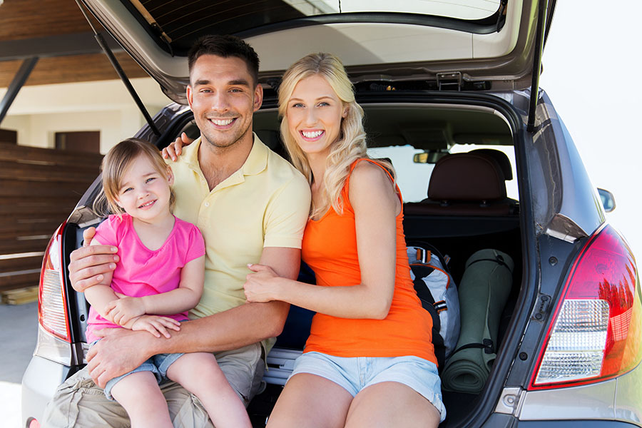 Personal Insurance - Portrait of Happy Family Sitting in the Trunk of Their Car at Home